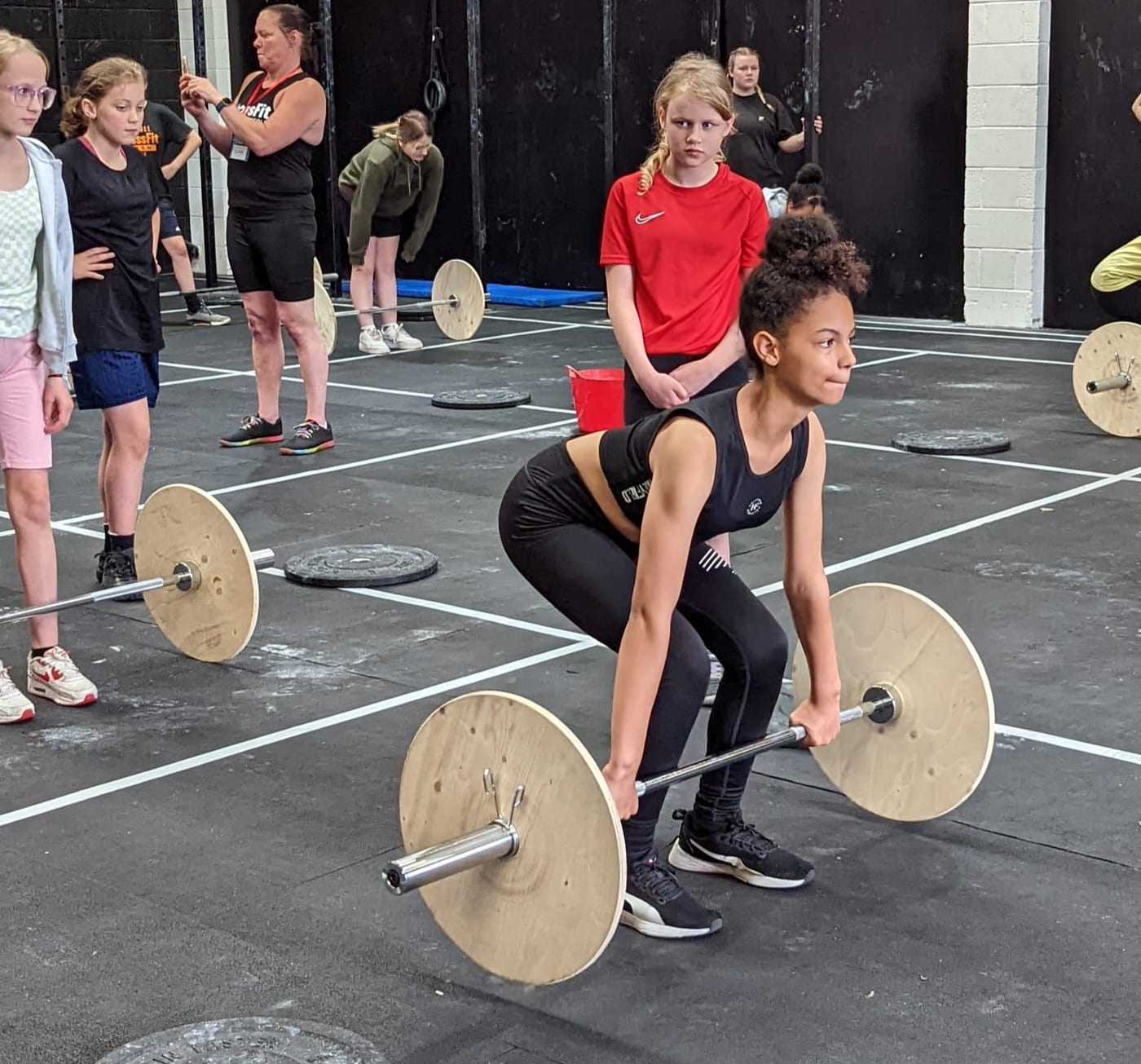 A girl performing a deadlift at a weightlifting session