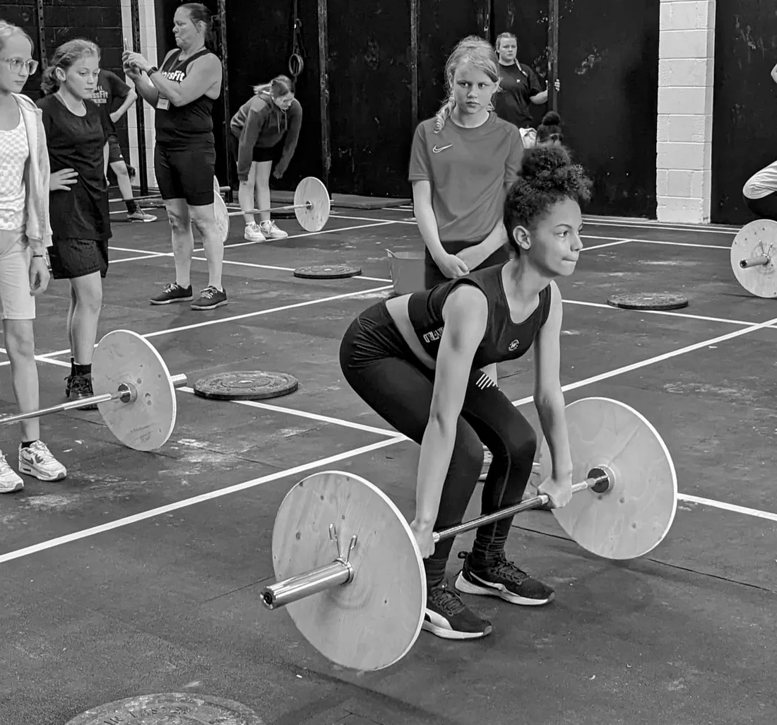 A girl performing a deadlift at a session